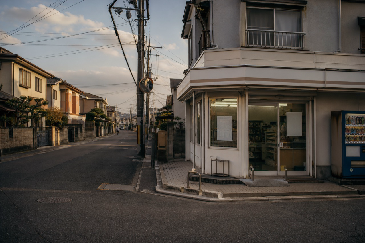 夕暮れの駅前広場、駐輪場と住宅街への道