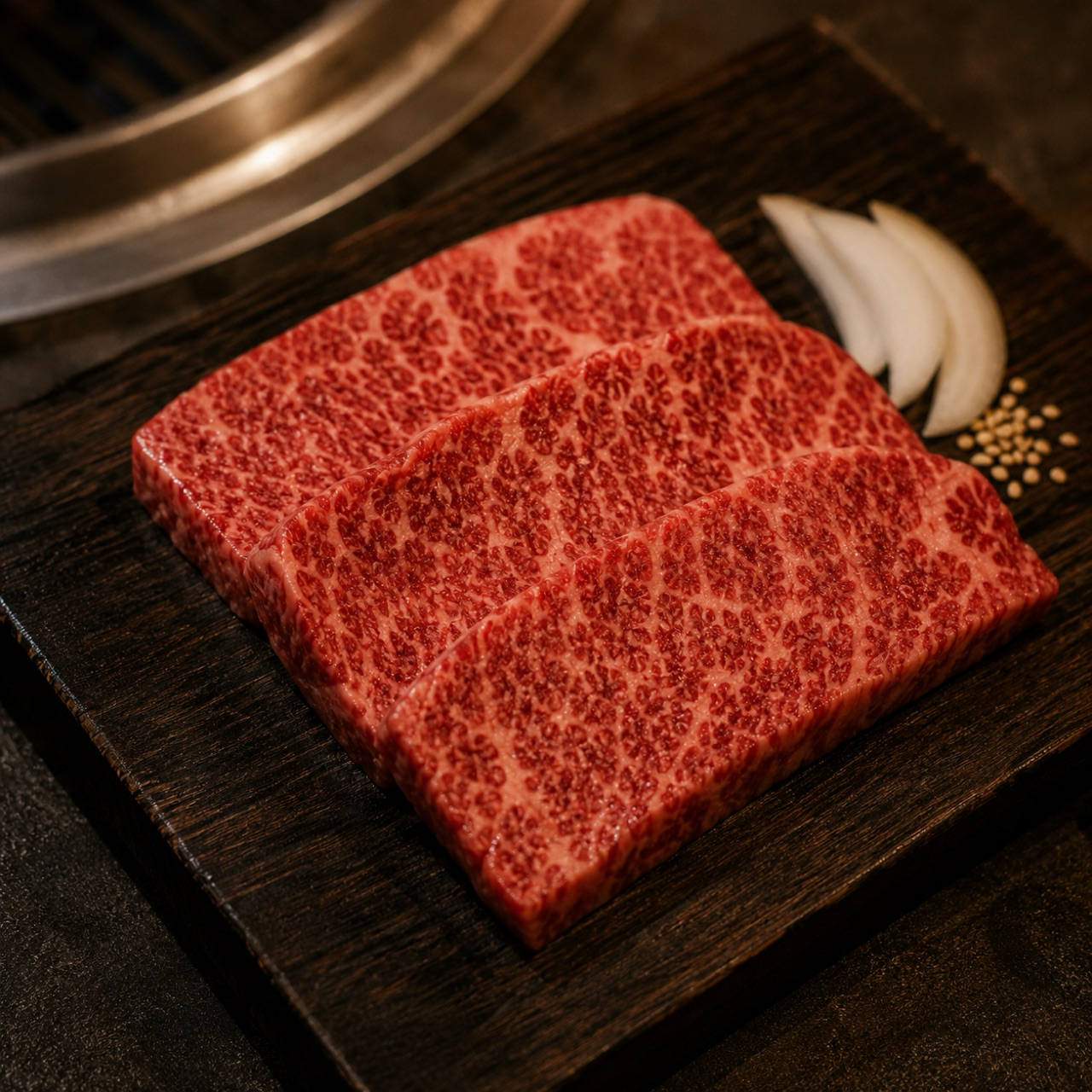 四角く切り出された細かいサシのイチボ、木の板に盛り